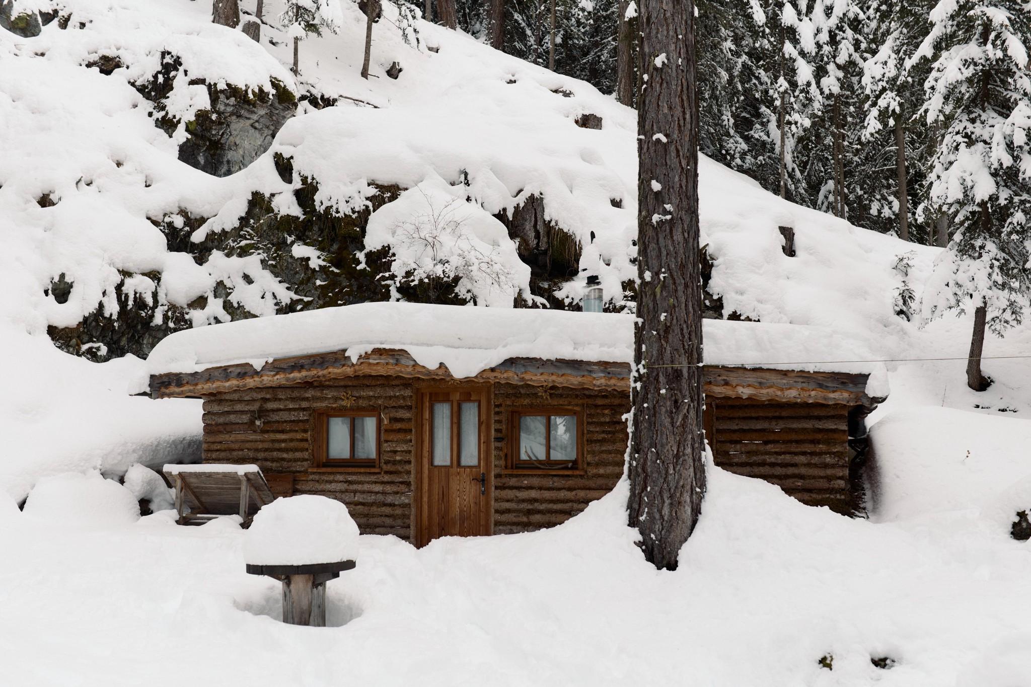 Rustic hunting lodge in deep snow.