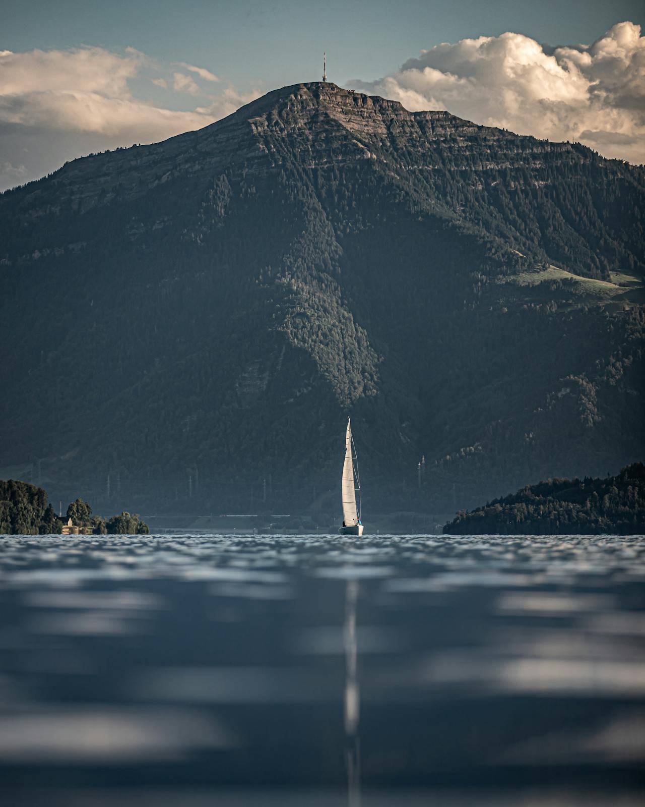 Bateau à voile devant un paysage de montagne.