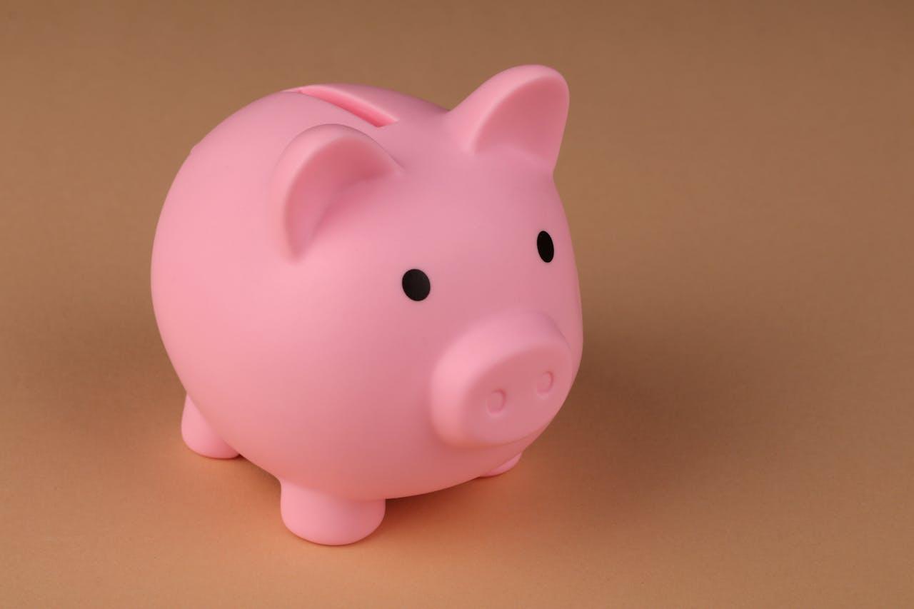 Rosa Sparschwein auf beigem Hintergrund.