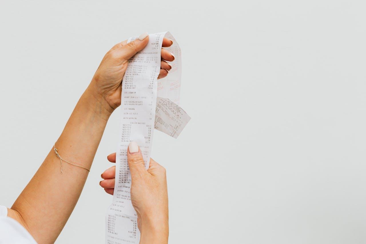 Person holds long shopping receipt.