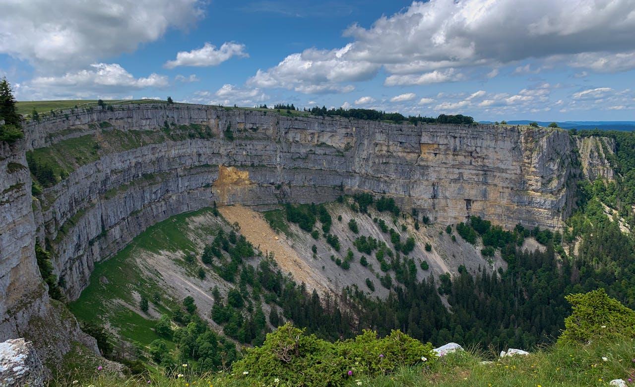 Steilklippe mit grünen Wäldern.