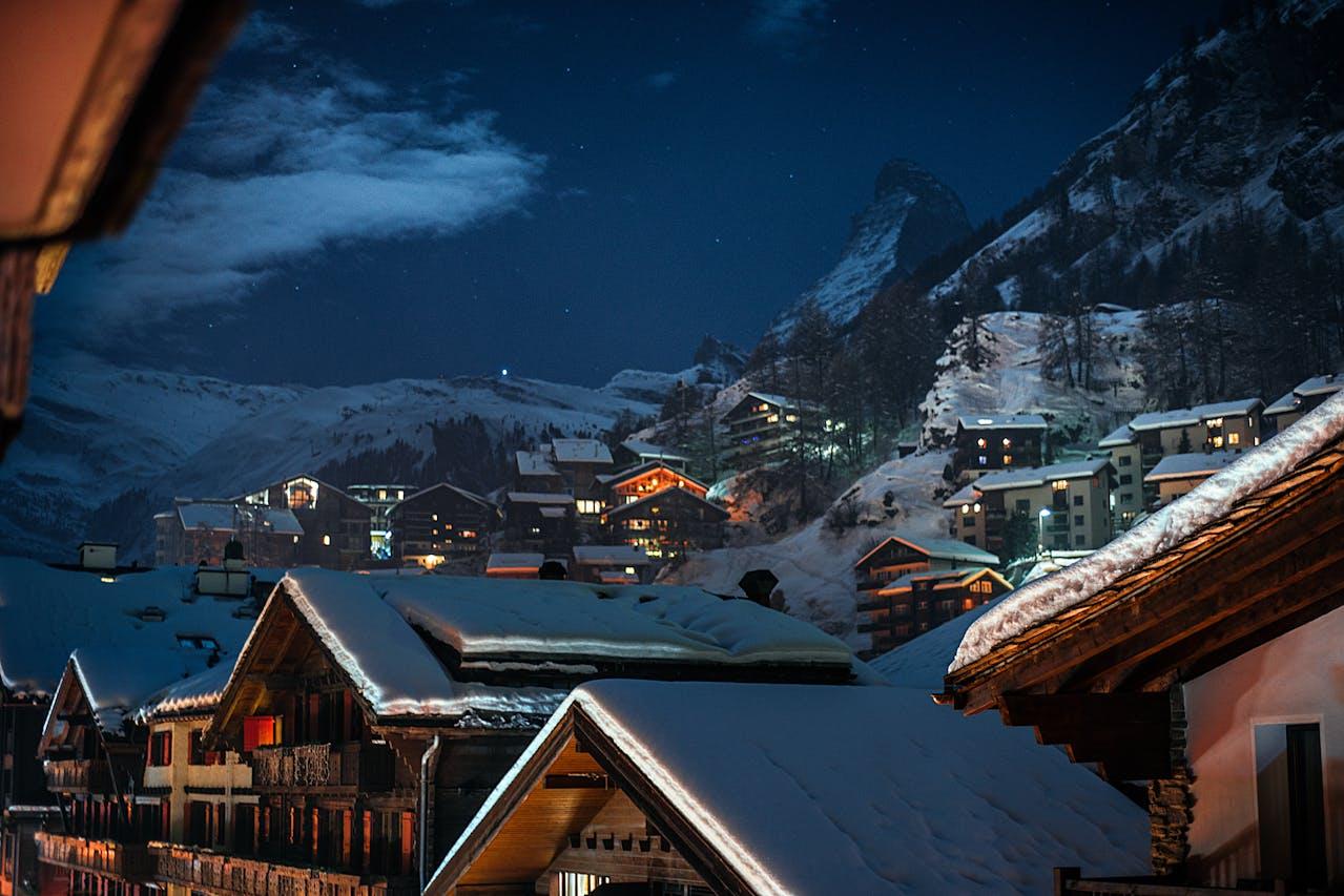 Villaggio di montagna innevato di notte.