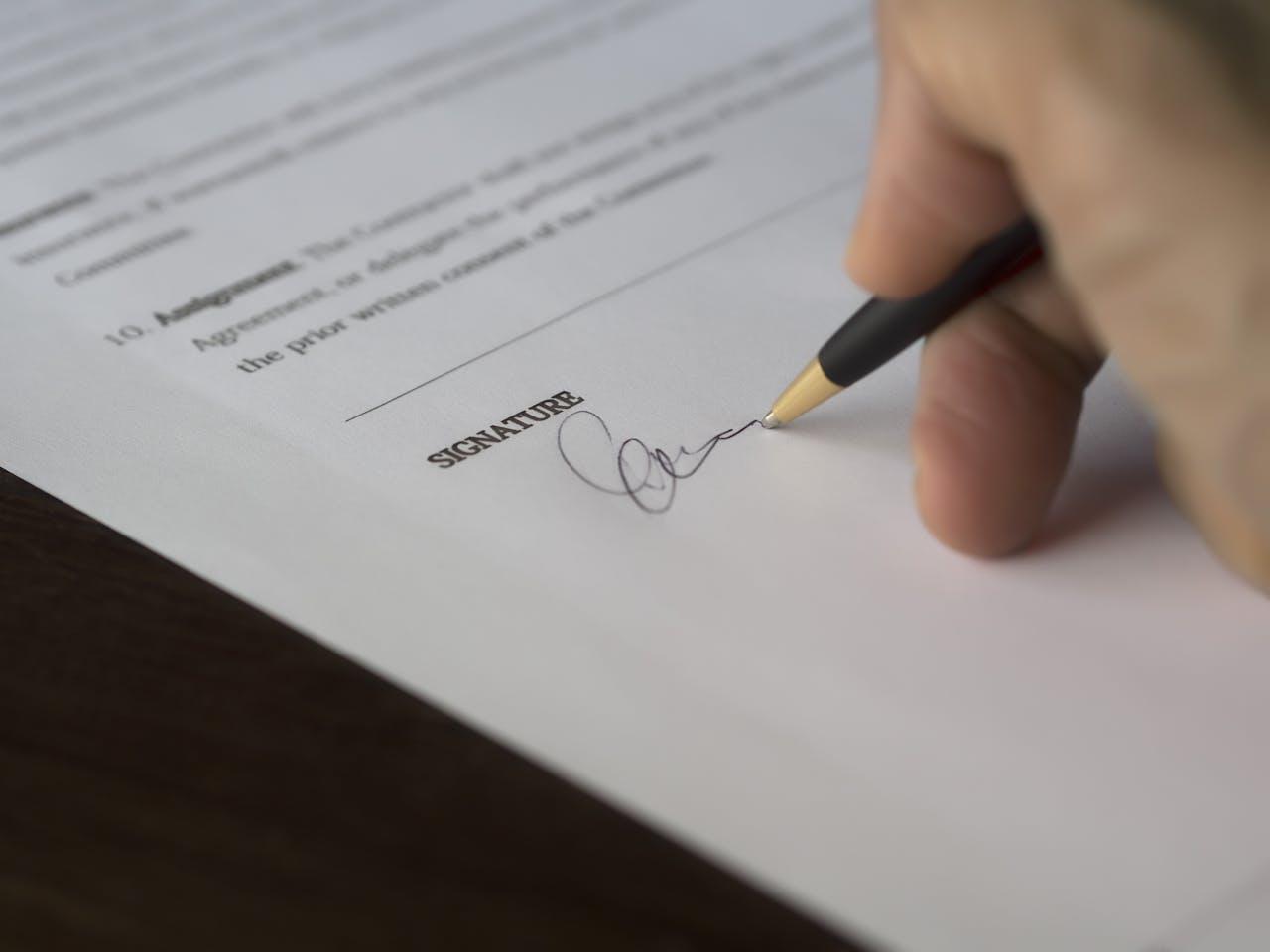 Hand signs contract with ballpoint pen.