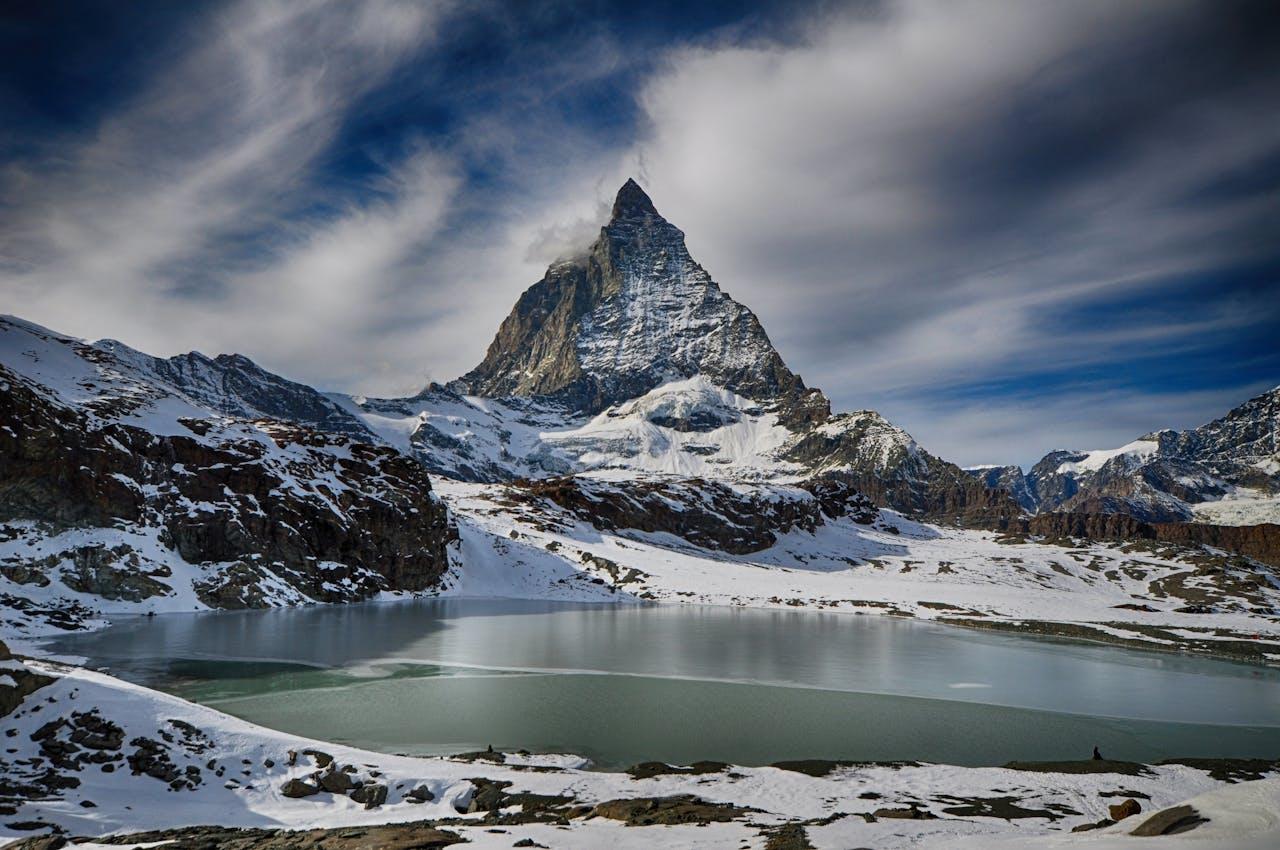 Matterhorn with snow-covered mountain landscape and lake.