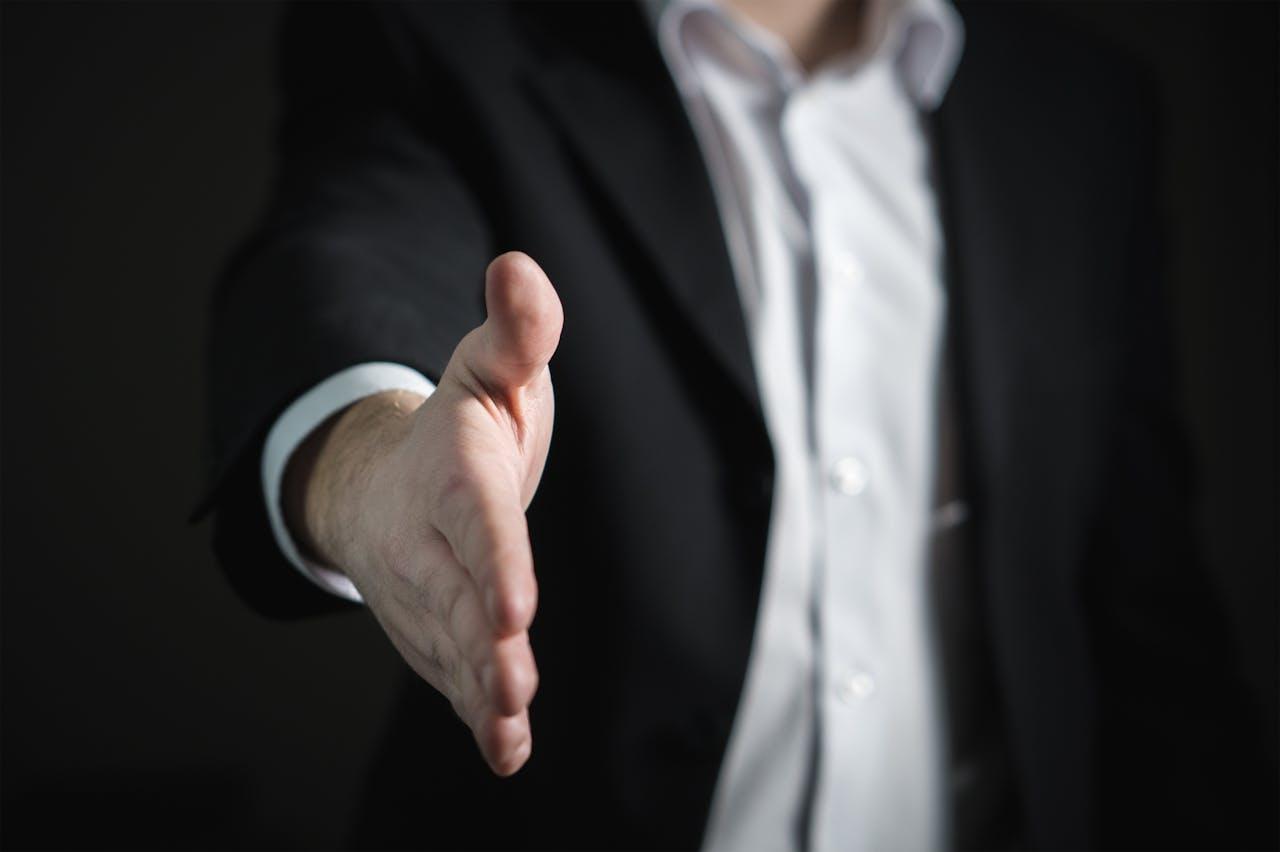 Businessman offers handshakes.