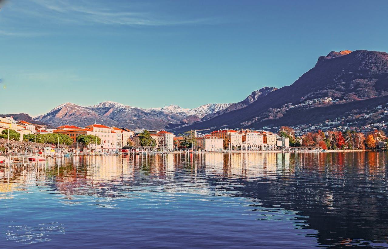Lake and mountain landscape with buildings.