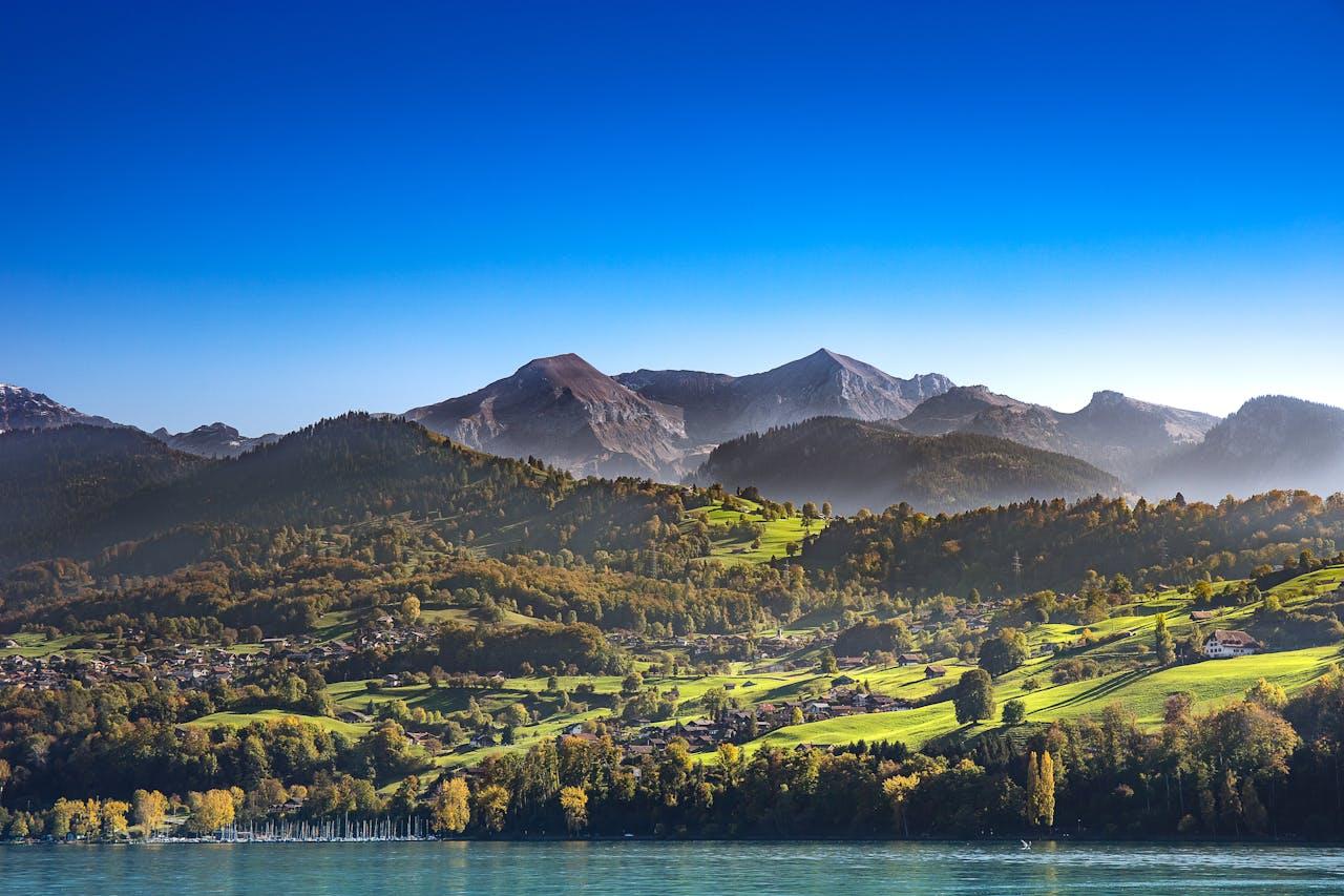 Bergpanorama mit See und grünen Hügeln.