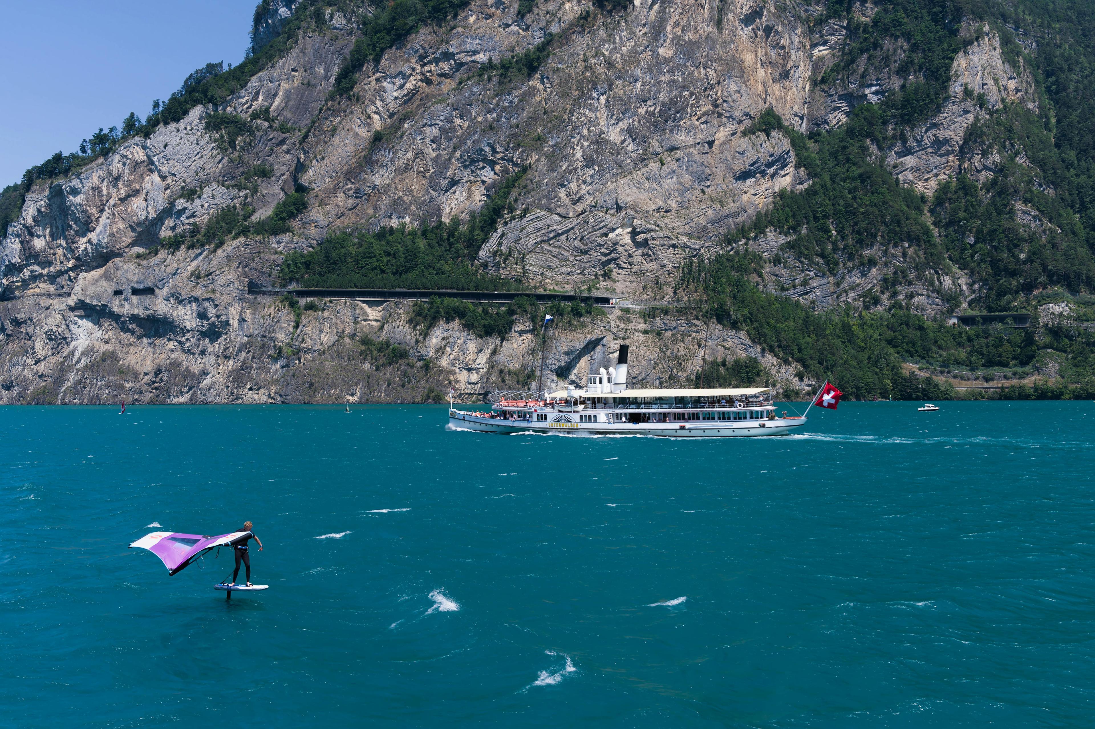 Kitesurfen vor Bergkulisse.