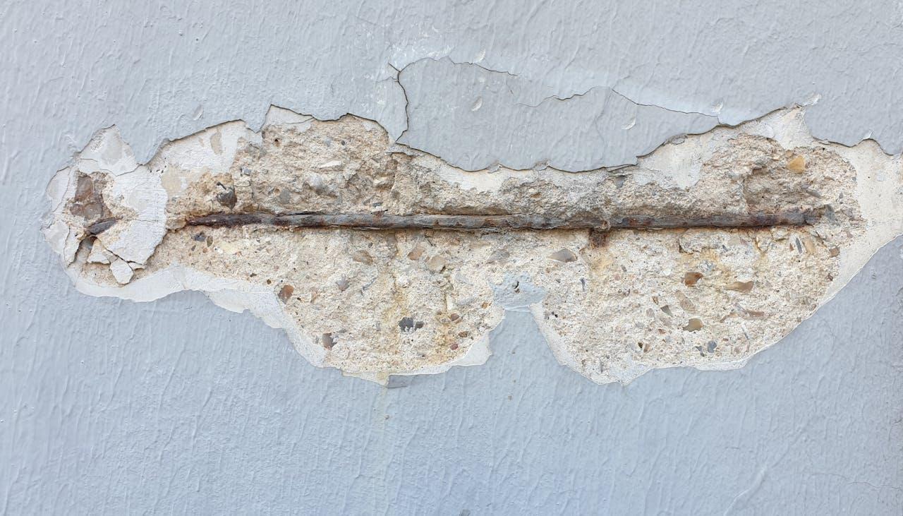 chipped plaster with visible reinforcement.